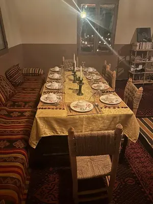a long table with plates and candles on it at farah desert camp in Kasr Bounou