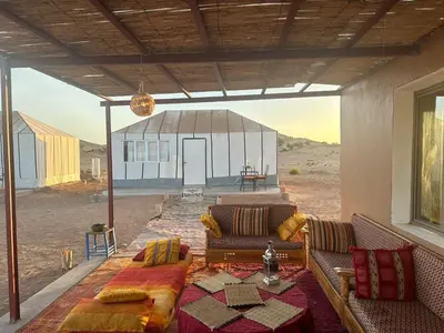 a living room with a couch in front of a building at farah desert camp in Kasr Bounou