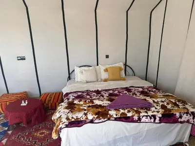 a bedroom with a bed in a tent at farah desert camp in Kasr Bounou