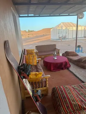 a snowboard leaning against the side of a building at farah desert camp in Kasr Bounou