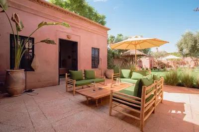 a patio with a table and chairs and an umbrella at Villa Boccara Marrakech in Chaibate