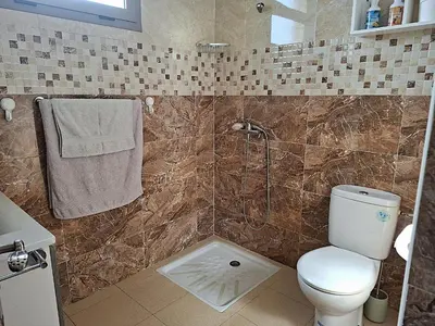 a bathroom with a shower with a toilet and a sink at Appartement cosy avec terrasse et solarium in Oulad Akkou
