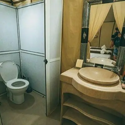 a bathroom with a sink and a toilet and a mirror at Holiday Bivouac in Merzouga