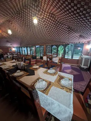 a dining room with a long table and chairs at Holiday Bivouac in Merzouga