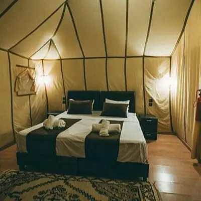 a bedroom with a large bed with two towels at Holiday Bivouac in Merzouga