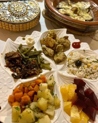 a table with plates of different types of food at Desert Live Luxury Camp in Merzouga