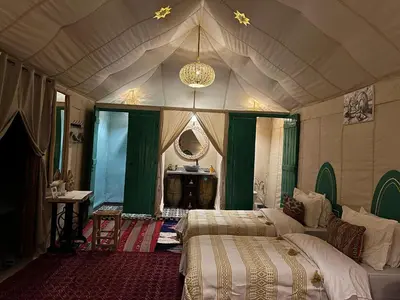 a bedroom with two beds and a chandelier at Desert Live Luxury Camp in Merzouga