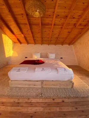 a large bed in a room with a wooden ceiling at La Pointe d'Or Dakhla in Oulad Akkou
