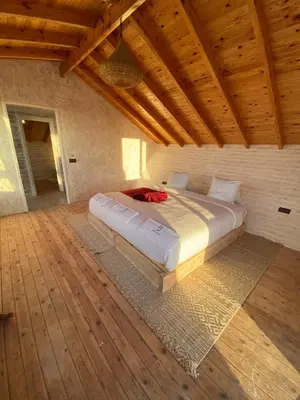 a large bed in a room with a wooden ceiling at La Pointe d'Or Dakhla in Oulad Akkou