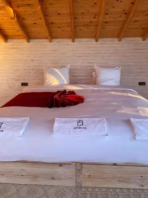 a large white bed in a wooden room at La Pointe d'Or Dakhla in Oulad Akkou