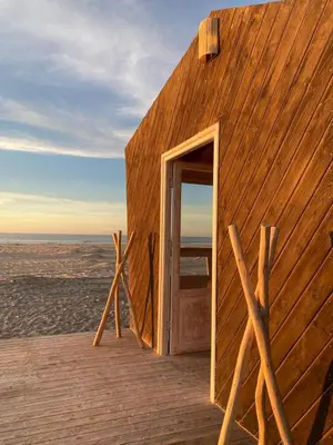a wooden building with an open door on the beach at La Pointe d'Or Dakhla in Oulad Akkou