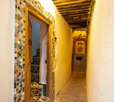 a hallway of a building with a door and tiles at Dar El Kendil in Fès