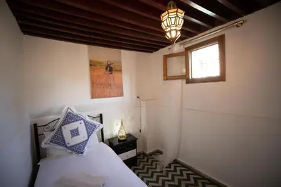 a bedroom with a bed and a window and a lamp at Dar El Kendil in Fès