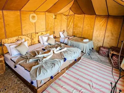 a room with two beds in a tent at Oasis Desert Luxury Camp in Merzouga