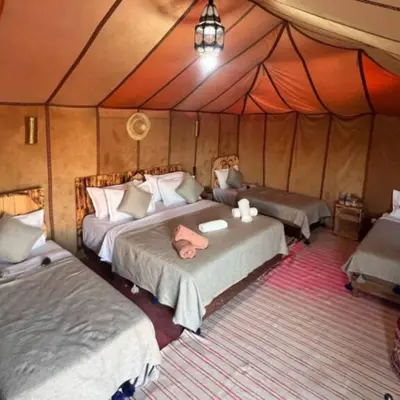 a bedroom with two beds in a tent at Oasis Desert Luxury Camp in Merzouga