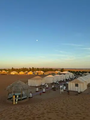 a group of tents in the sand on a beach at Oasis Desert Luxury Camp in Merzouga
