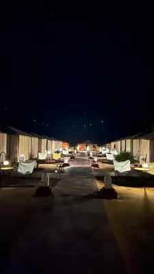a group of chairs and tables in a parking lot at night at Oasis Desert Luxury Camp in Merzouga
