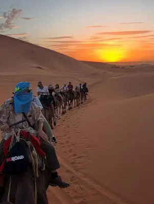 a group of people riding horses in the desert at Oasis Desert Luxury Camp in Merzouga