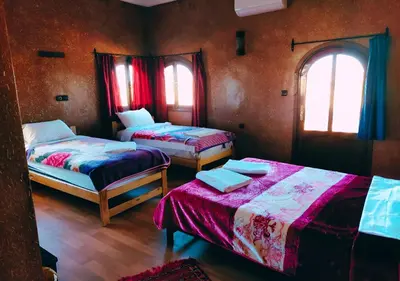 a room with two beds and two windows at SUD-EST palace in Ait Gmat