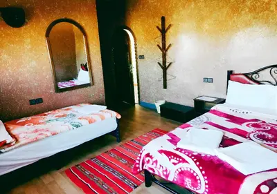 a bedroom with two beds and a mirror at SUD-EST palace in Ait Gmat