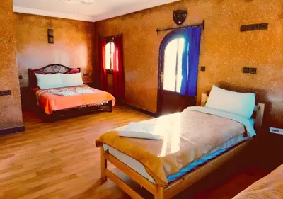 a bedroom with two beds and a window at SUD-EST palace in Ait Gmat