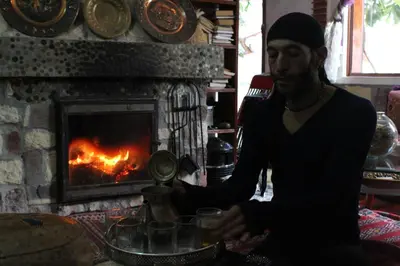 a man is standing in front of a fireplace at Maison d'hotes Ait Bou Izryane in Timoulilt