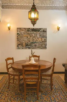 a dining room table with chairs and a chandelier at Appartement tout confort in Fès
