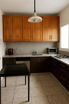 a kitchen with wooden cabinets and a table in it at Appartement tout confort in Fès