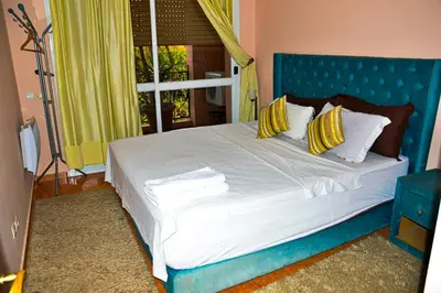 a blue bed with yellow pillows in a bedroom at appartement el harti in Oulad Akkou