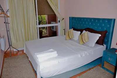 a bed with a blue headboard and pillows on it at appartement el harti in Oulad Akkou
