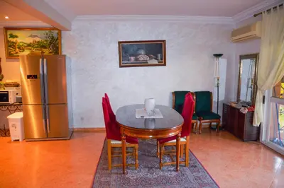 a kitchen with a table and chairs and a refrigerator at appartement el harti in Oulad Akkou