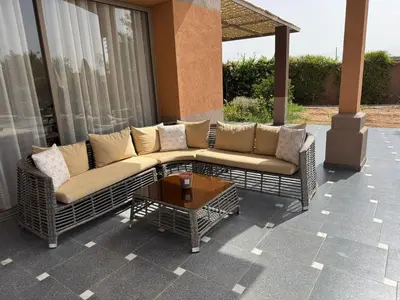 a couch and a coffee table on a patio at Luxury family villa with private pool in Douar bel Rhanodour