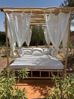 a bed with a canopy and white curtains at Luxury family villa with private pool in Douar bel Rhanodour
