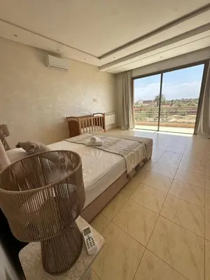 a bedroom with a bed and a large window at Luxury family villa with private pool in Douar bel Rhanodour