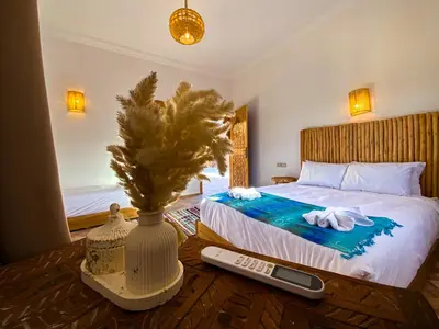 a bedroom with a bed with a vase and a remote control at Dar Bikouch in Aït Ben Haddou