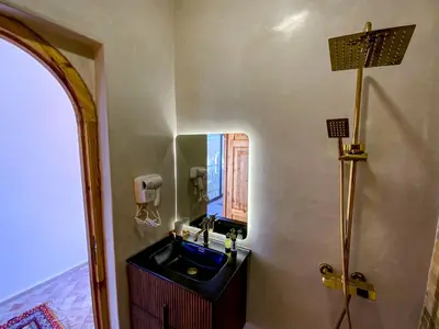 a bathroom with a sink and a mirror at Dar Bikouch in Aït Ben Haddou