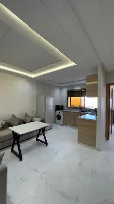 a large living room with a table and a kitchen at luxury Apartments Complete Building in Fez in Douar Trhaïtia