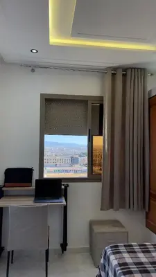a bedroom with a desk and a window with a laptop at luxury Apartments Complete Building in Fez in Douar Trhaïtia