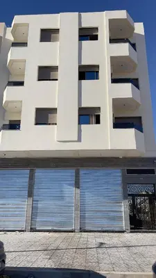 a large white building with two large garage doors at luxury Apartments Complete Building in Fez in Douar Trhaïtia