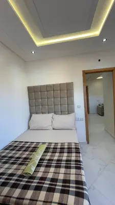 a bedroom with a large bed with a checkered blanket at luxury Apartments Complete Building in Fez in Douar Trhaïtia
