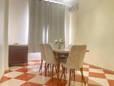 a dining room table with chairs and a vase of flowers at Résidence Kawtar in Meknès