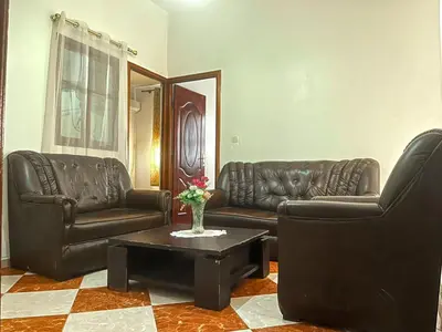 a living room with two leather couches and a coffee table at Résidence Kawtar in Meknès