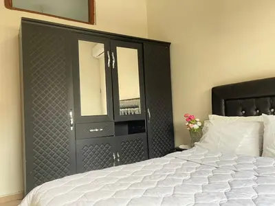 a bedroom with a black headboard and a white bed at Résidence Kawtar in Meknès