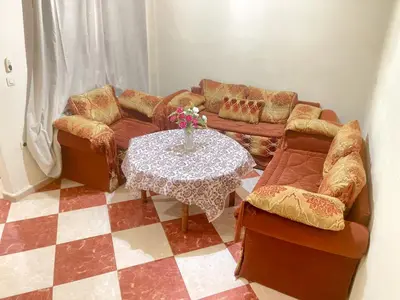 a living room with a couch and a table and chairs at Résidence Kawtar in Meknès