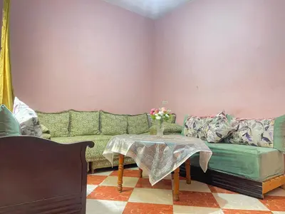 a living room with a green couch and a table at Résidence Kawtar in Meknès