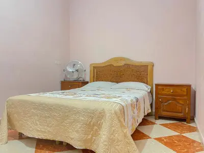 a bedroom with a bed with a wooden headboard and a night stand at Résidence Kawtar in Meknès