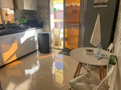 a kitchen with a table and a small table and a table and chairs at Apartment Private room in apartment in Khouribga in Khouribga