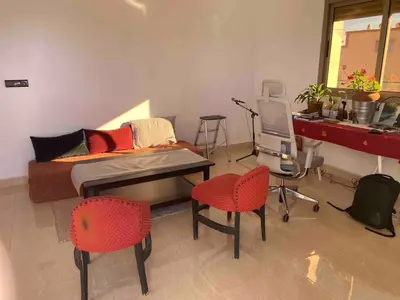 a bedroom with a bed and two chairs and a desk at Apartment Private room in apartment in Khouribga in Khouribga