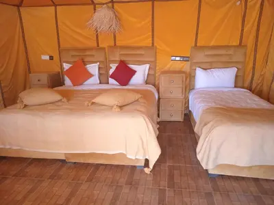 a bedroom with two beds in a tent at Good vibes desert camp in Merzouga