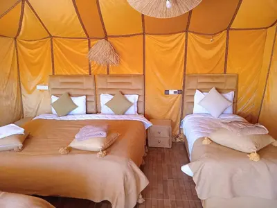 a bedroom with two beds in a tent at Good vibes desert camp in Merzouga